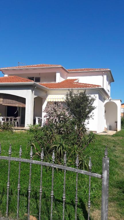 une maison blanche avec une clôture devant elle dans l'établissement App. Adriatic Aurora, à Umag