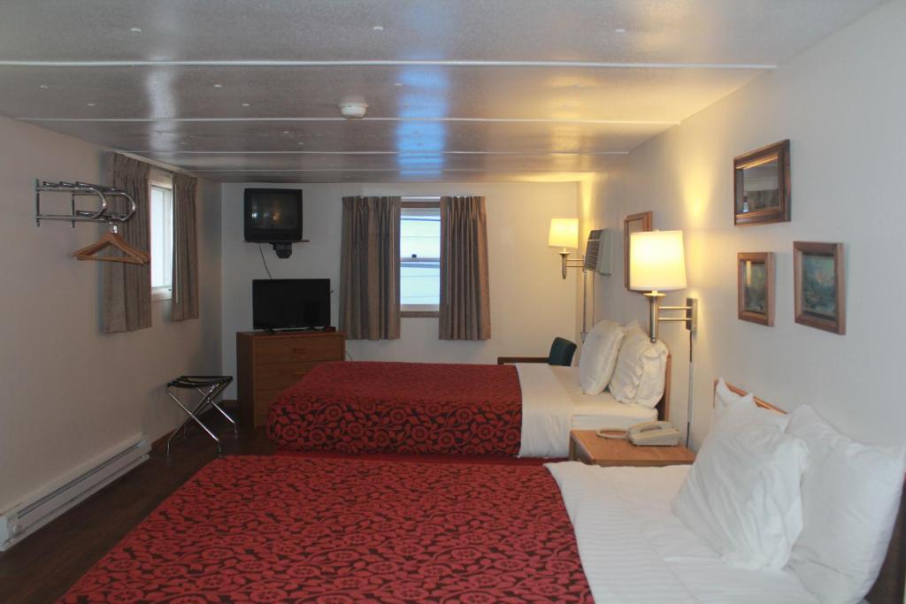 a hotel room with two beds and a red rug at The Brookside Motel / Mt. Rushmore in Keystone