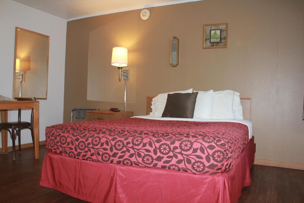 a hotel room with a bed with a red blanket at The Brookside Motel / Mt. Rushmore in Keystone
