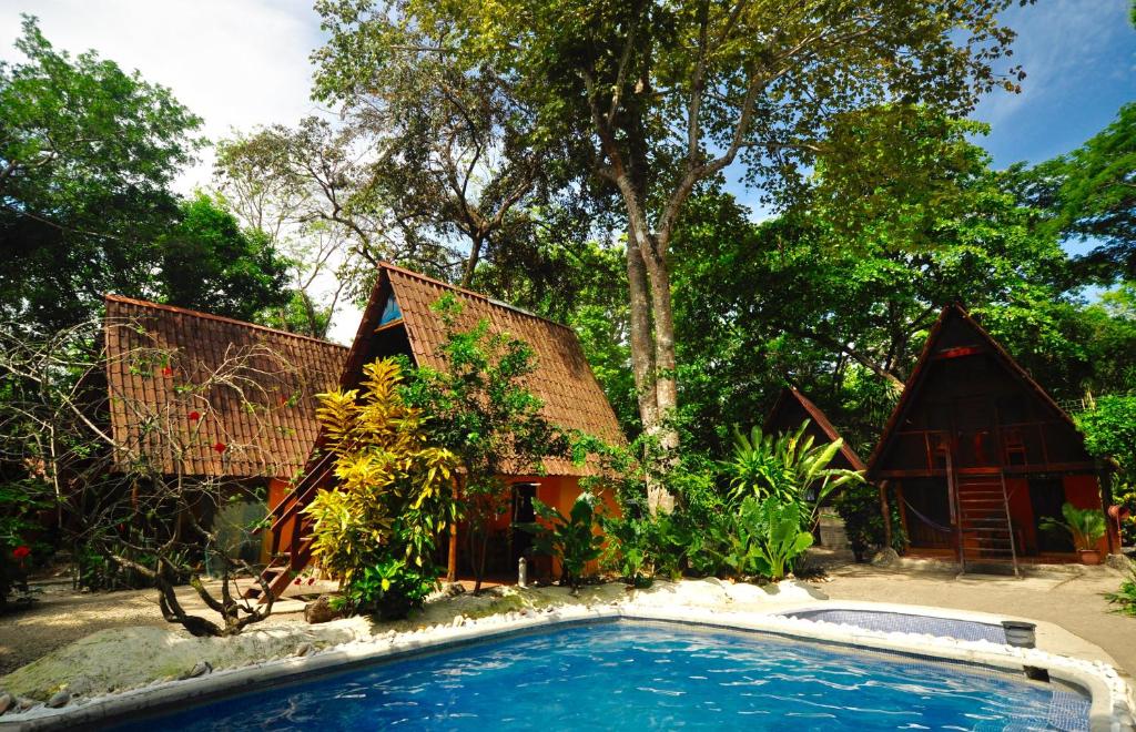 una casa con piscina frente a ella en Howler Monkey Hotel, en Montezuma