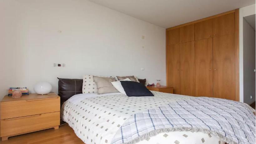 um quarto com uma cama e um armário de madeira em My Oriente em Lisboa