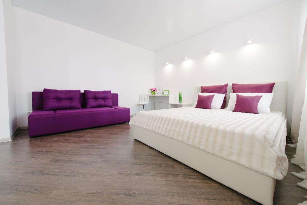 イジェフスクにあるFive Stars Studioのベッドルーム(大型ベッド1台、紫色のソファ付)