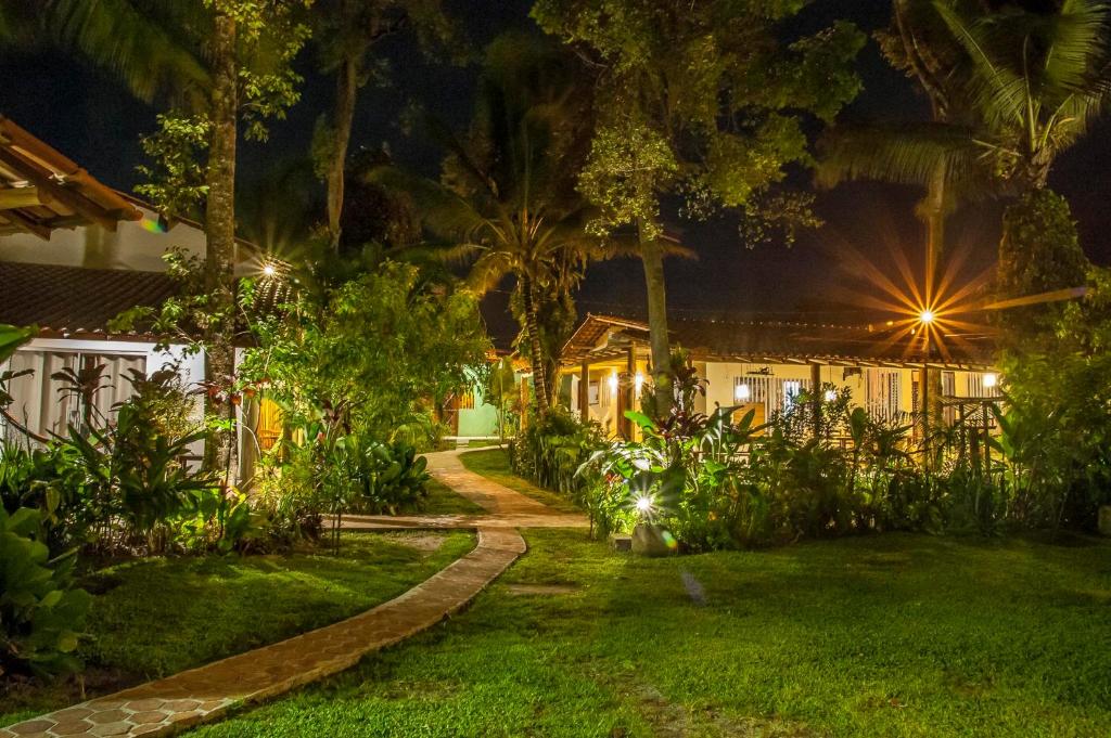 uma casa com jardim à noite em Pousada Peki em Arraial d'Ajuda