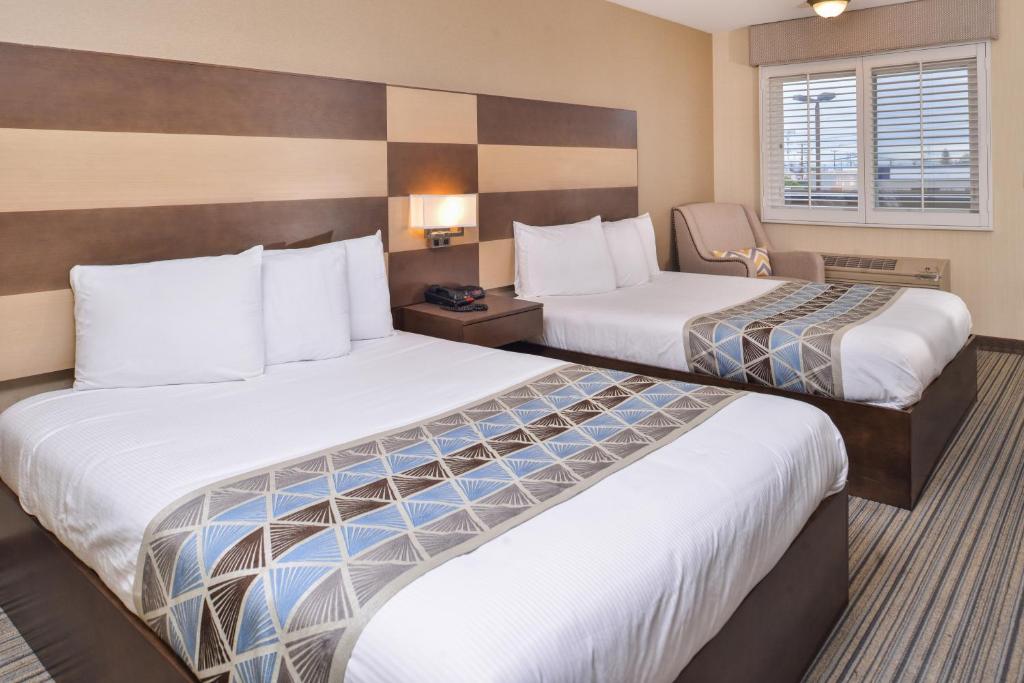 una camera d'albergo con due letti e una sedia di Good Living Inn a San Carlos