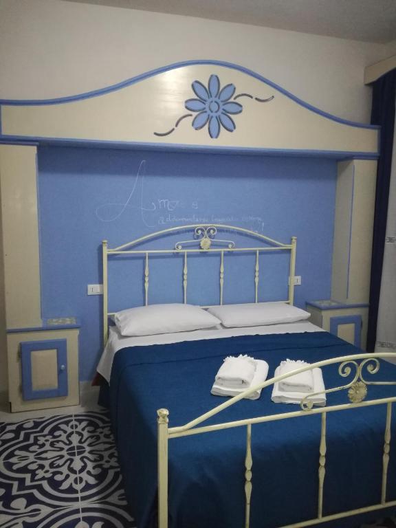 a blue bedroom with a bed with a blue wall at Benvenuti al Sud B&B in Macari