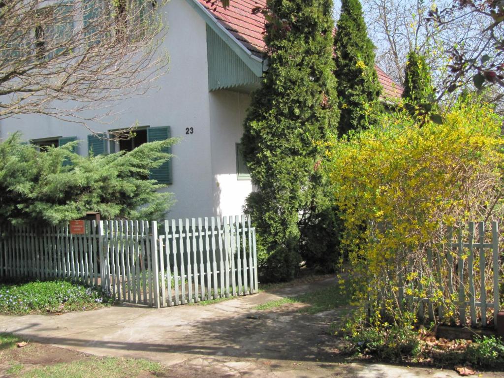 a white house with a white picket fence at Babarczi Üdülőház in Kiskunmajsa