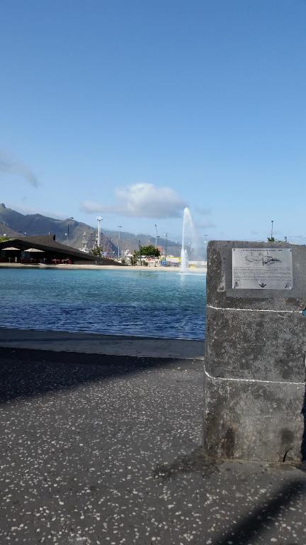 een stenen bank naast een waterlichaam bij Habitacion con baño privado in Santa Cruz de Tenerife