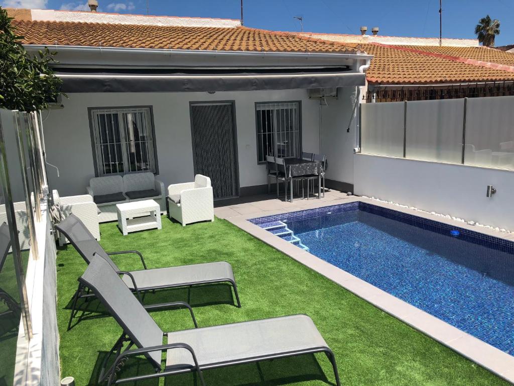 un patio trasero con piscina y césped en Casa Pequeno, en San Javier