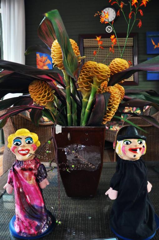 two dolls standing next to a potted plant at Hotel Aranjuez in San José