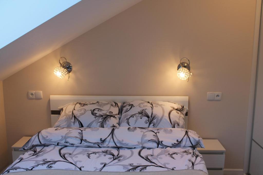 łóżko w sypialni z dwoma światłami na ścianie w obiekcie Apartament "Zacisze" w Łukęcinie