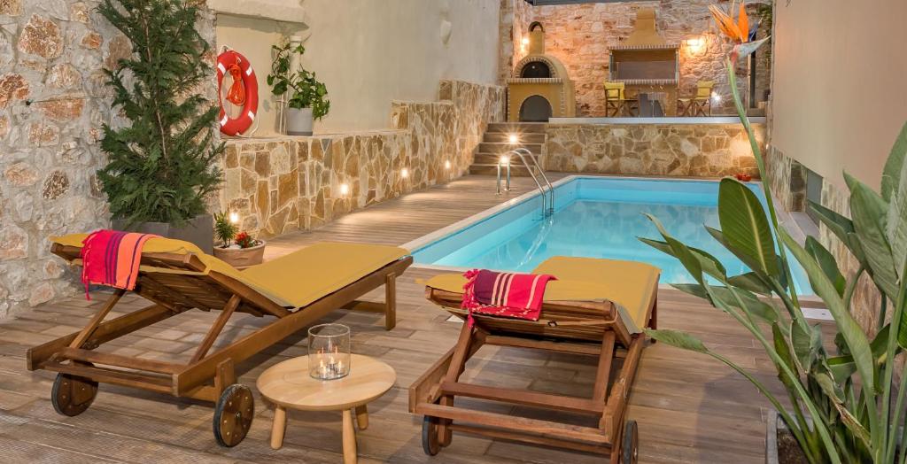 basen z 2 leżakami i basen w obiekcie Villa Armonia Boutique Living w mieście Dhrakóna