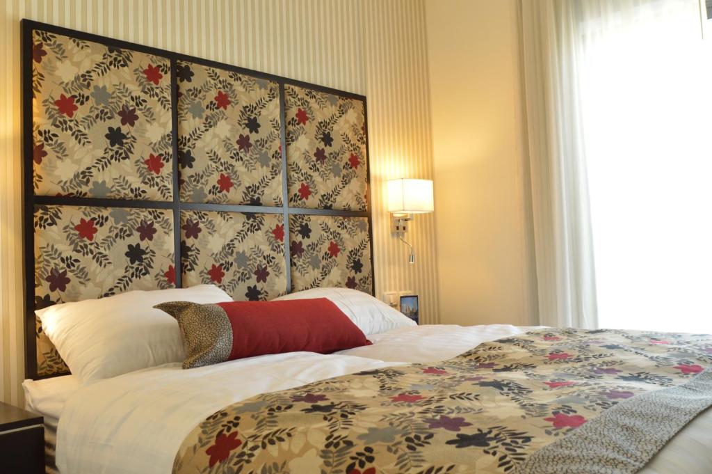 
a bed with a white comforter and pillows at Shamai Suites Jerusalem in Jerusalem
