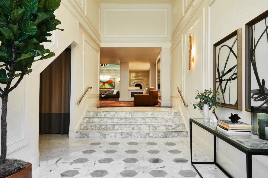 a hallway with a staircase and a living room at Galleria Park Hotel in San Francisco