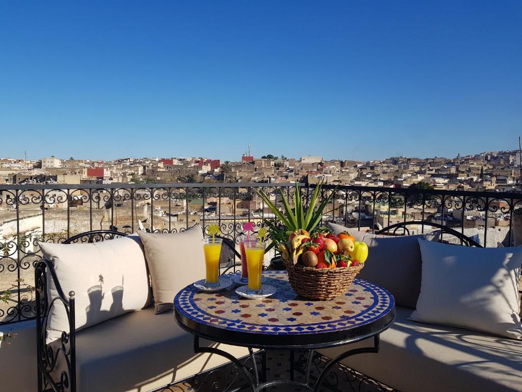 a table with a basket of fruit on a balcony at Riad Fes Kettani in Fez