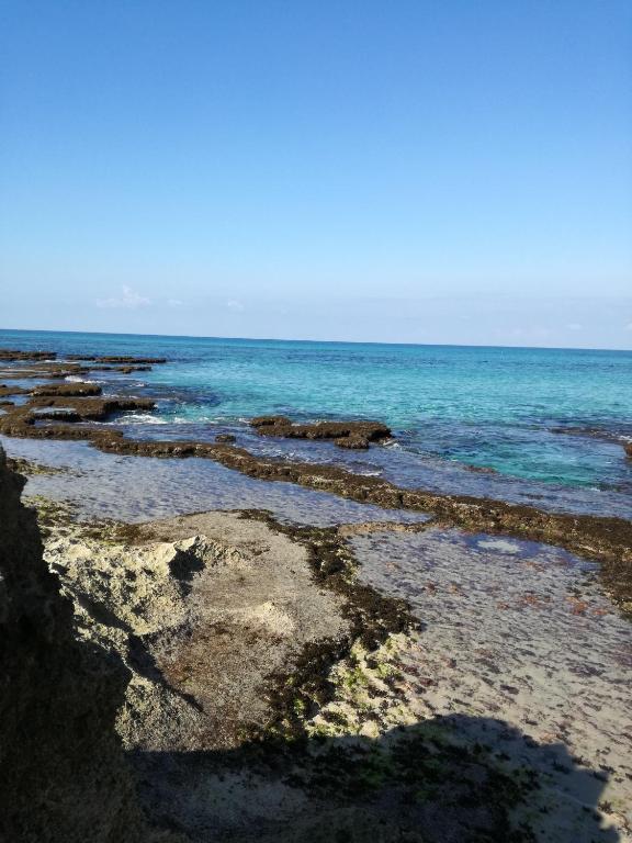 a beach with rocks and the ocean at Benvenuti al Sud B&B in Macari