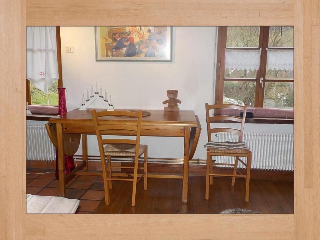 uma sala de jantar com uma mesa de madeira e cadeiras em La Pouponiere em Sainte-Marie-aux-Mines