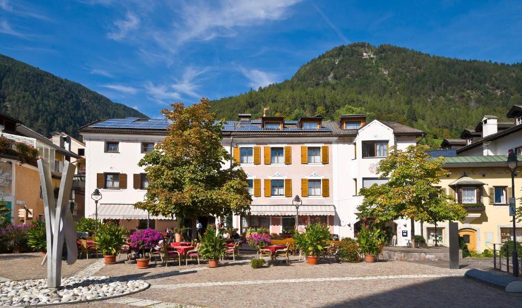 a large white building with a mountain in the background at Hotel Seppi in Mühlbach