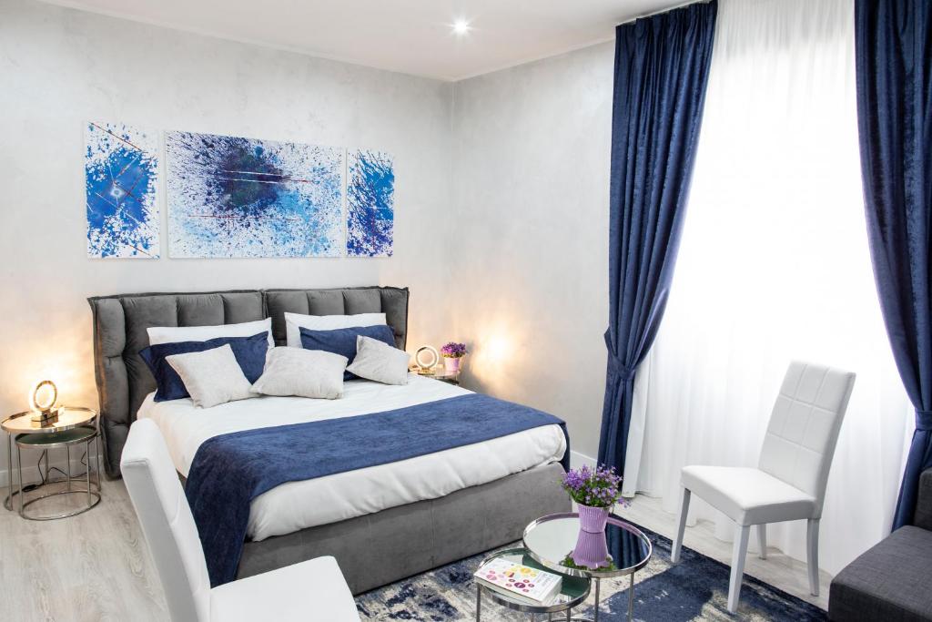 - une chambre avec un lit bleu et blanc et une chaise dans l'établissement Il Magnificus Boutique, à Rome
