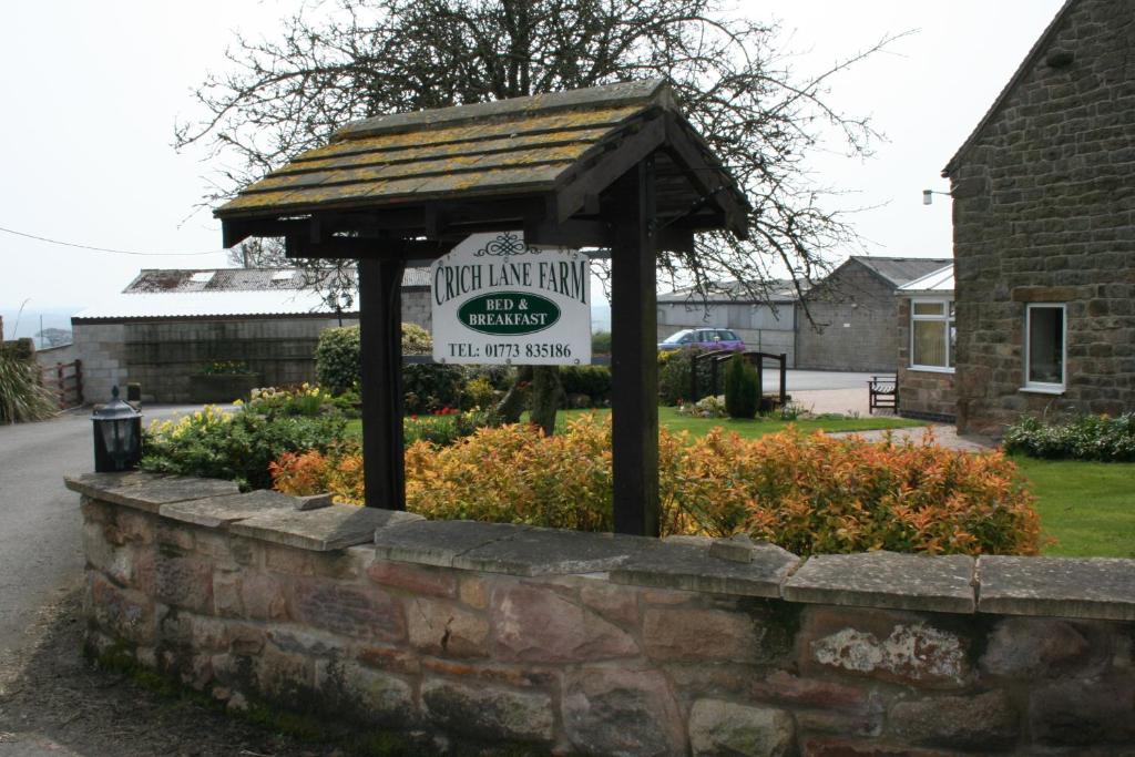 un cartel en una pared de piedra en un patio en Crich Lane Farm, en Alfreton