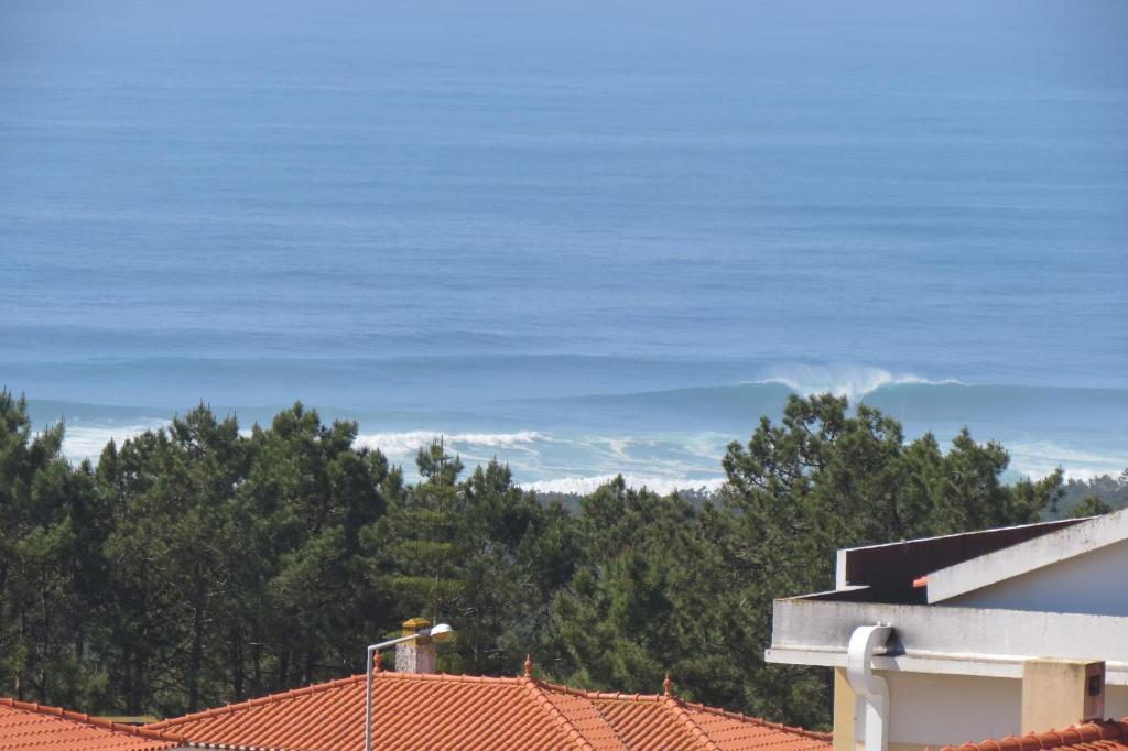 einen Blick auf die Dächer von Häusern und Bäumen in der Unterkunft Relax & Sea View Apartment in Nazaré