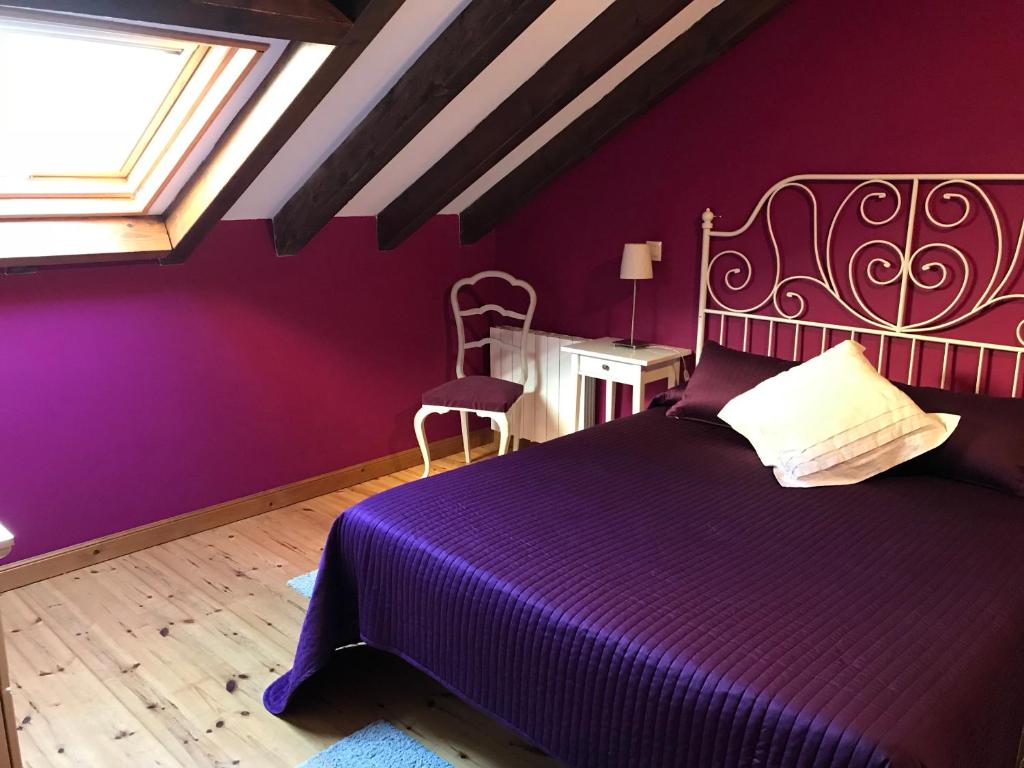 サンティリャーナ・デル・マルにあるEn busca del viento del norteの紫色のベッドルーム(ベッド1台、窓付)