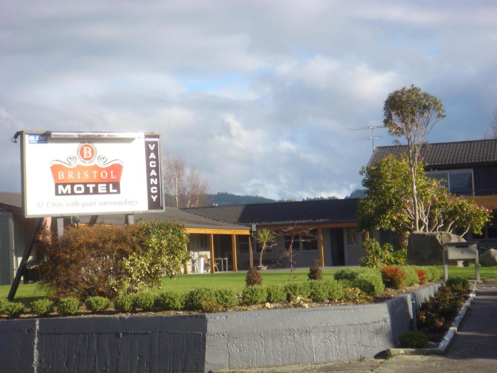 um sinal para um hotel em frente a uma casa em Bristol Motel em Upper Hutt