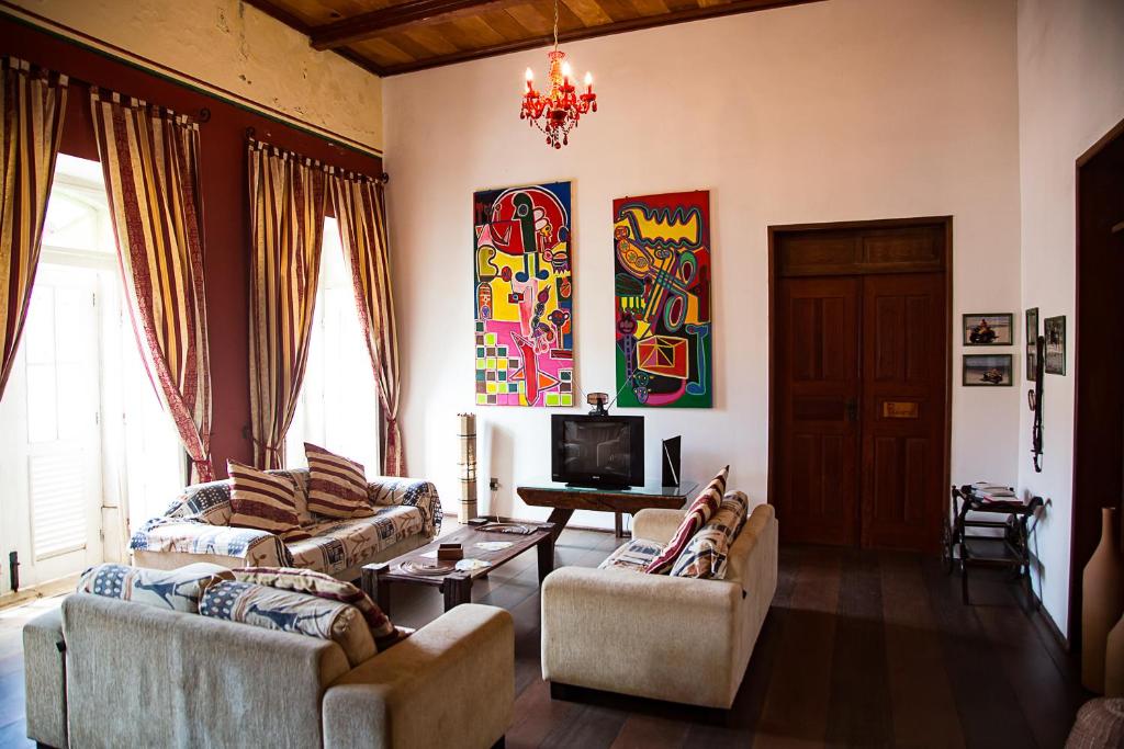 a living room with two couches and a tv at Casa Lavinia in São Luís