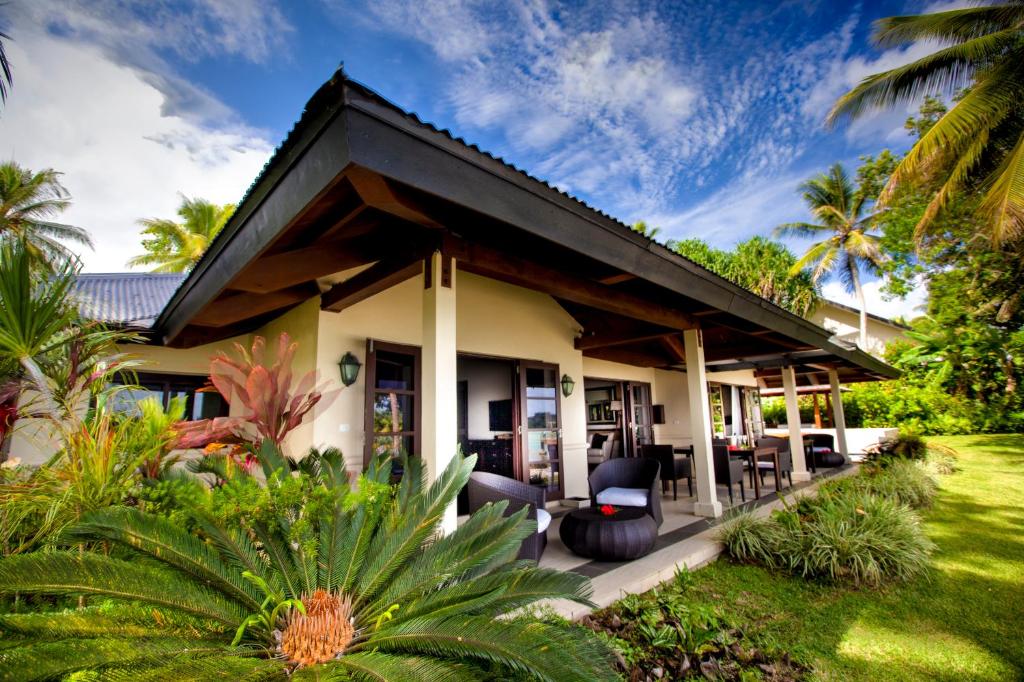 ein Haus mit einer Terrasse und Gartenanlagen in der Unterkunft Warwick Le Lagon Resort & Spa, Vanuatu in Port Vila