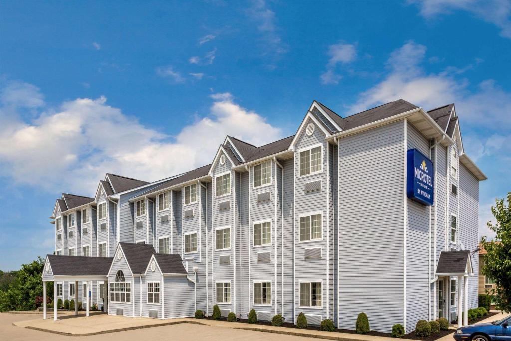 un grande edificio bianco con un cartello blu sopra di Microtel Inn & Suites by Wyndham Dry Ridge a Dry Ridge
