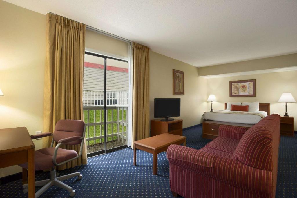 um quarto de hotel com uma cama e uma varanda em Affordable Suites of America Grand Rapids em Grand Rapids