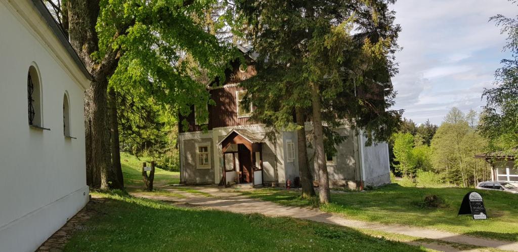 an old house with a tree in the yard at Wodolenka in Hrádek