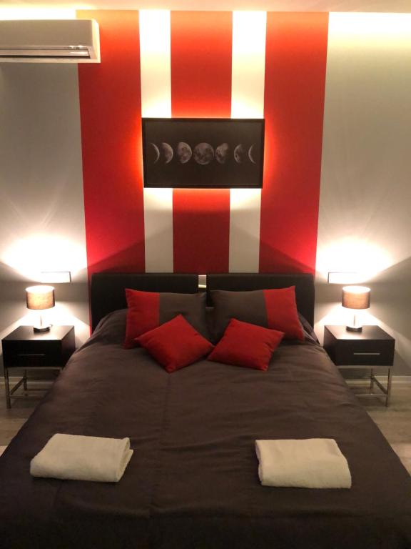 a bedroom with a large bed with red and white stripes at Bon apetit apartament in Lviv