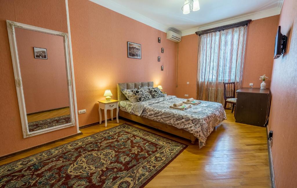 a bedroom with a bed and a large mirror at Alpha Tbilisi in Tbilisi City