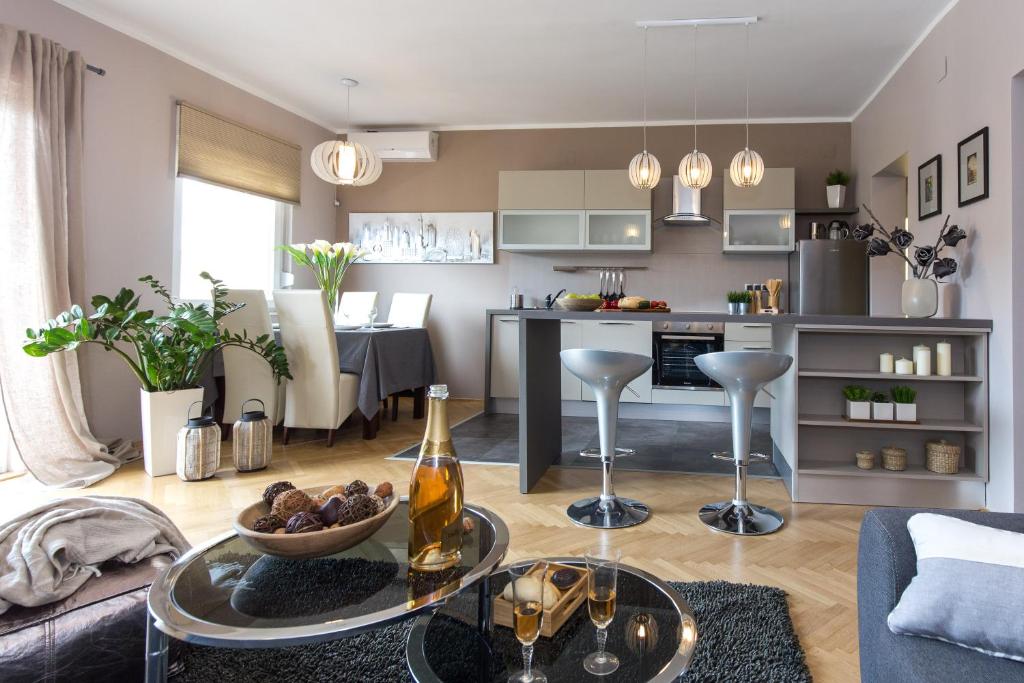 a living room with a couch and a table and a kitchen at Apartmani Violic in Punat