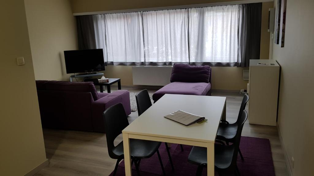 uma sala de estar com uma mesa e um sofá em Mathilda - apartments em Grobbendonk