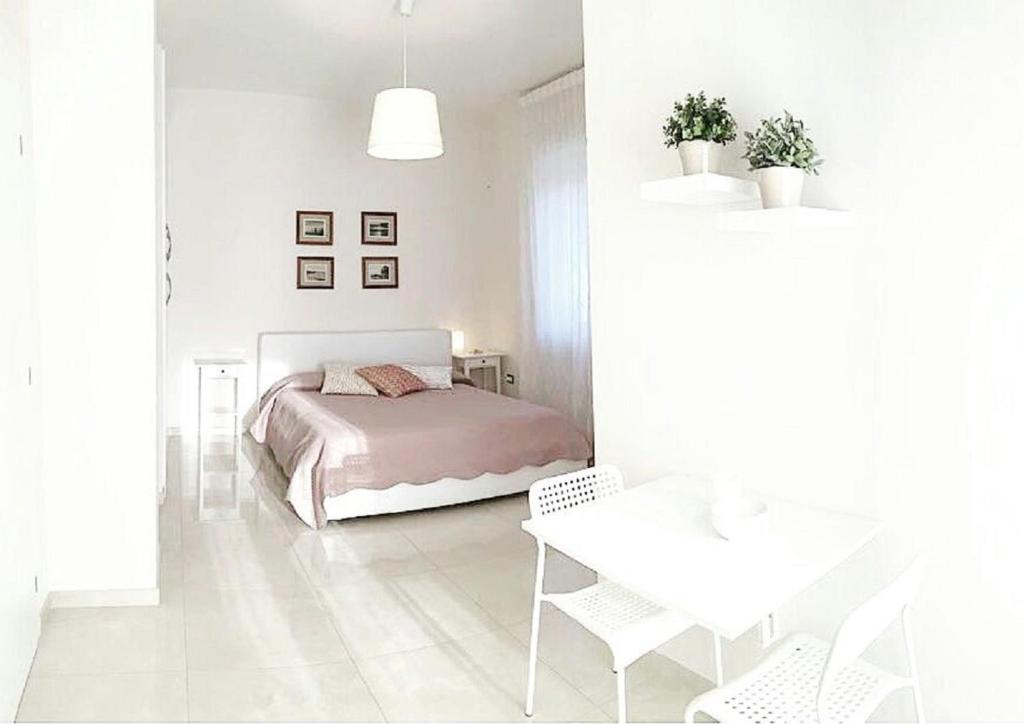 ein weißes Schlafzimmer mit einem Bett und einem Tisch in der Unterkunft B&B La Suite Gallipoli in Gallipoli