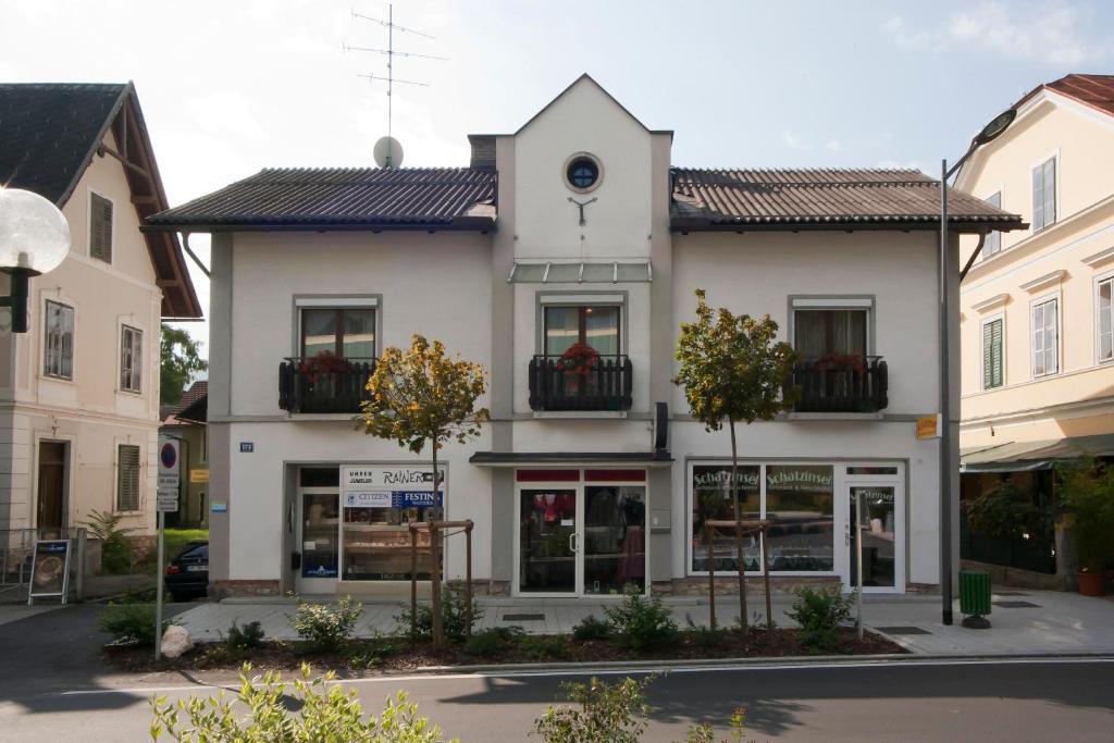 a large white building with windows in a street at Ferienwohnungen Pickert in Pörtschach am Wörthersee