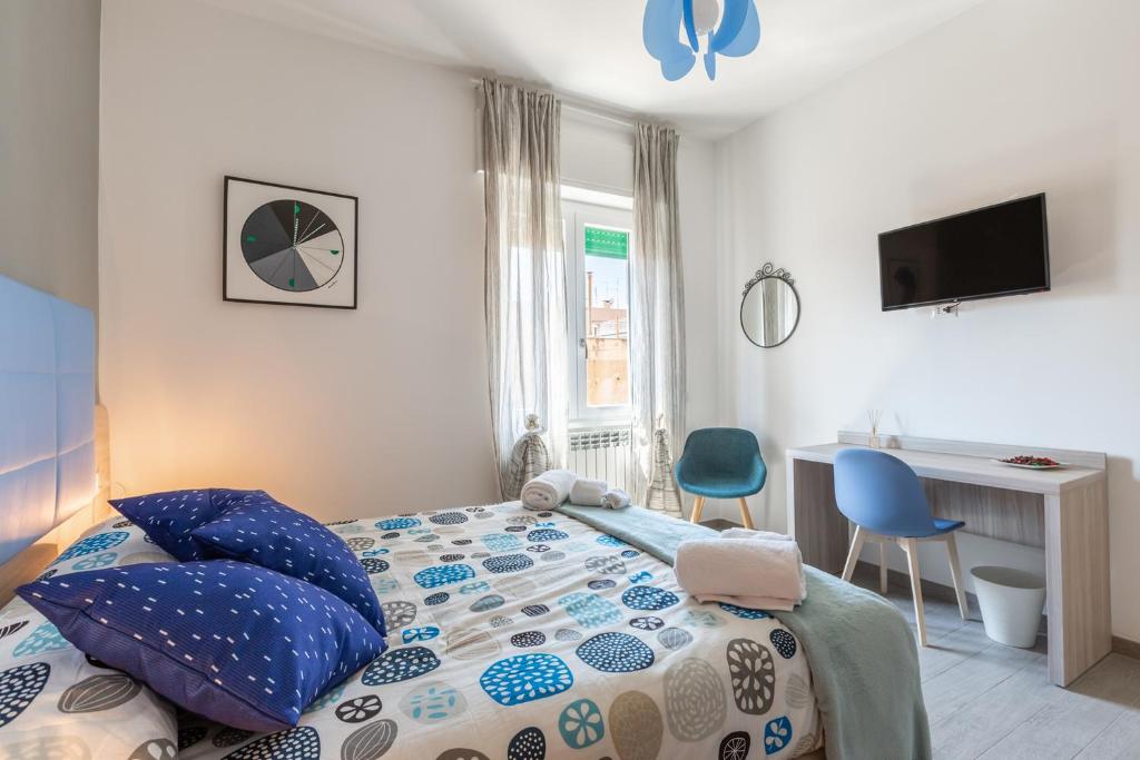 Schlafzimmer mit einem Bett mit blauen Kissen und einem Schreibtisch in der Unterkunft La Casa di Anto in Rom