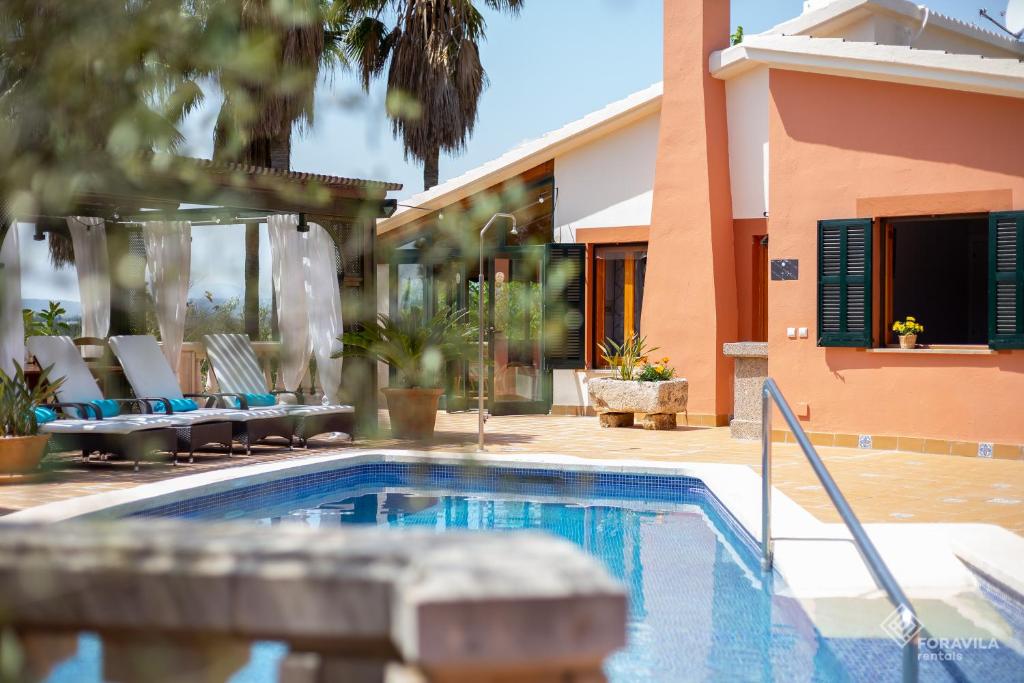 una piscina con sillas y una casa en Finca Can Marti, en Alcudia