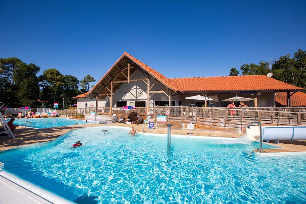 een groot zwembad met mensen in het water bij Camping Officiel Siblu Domaine de Soulac in Soulac-sur-Mer