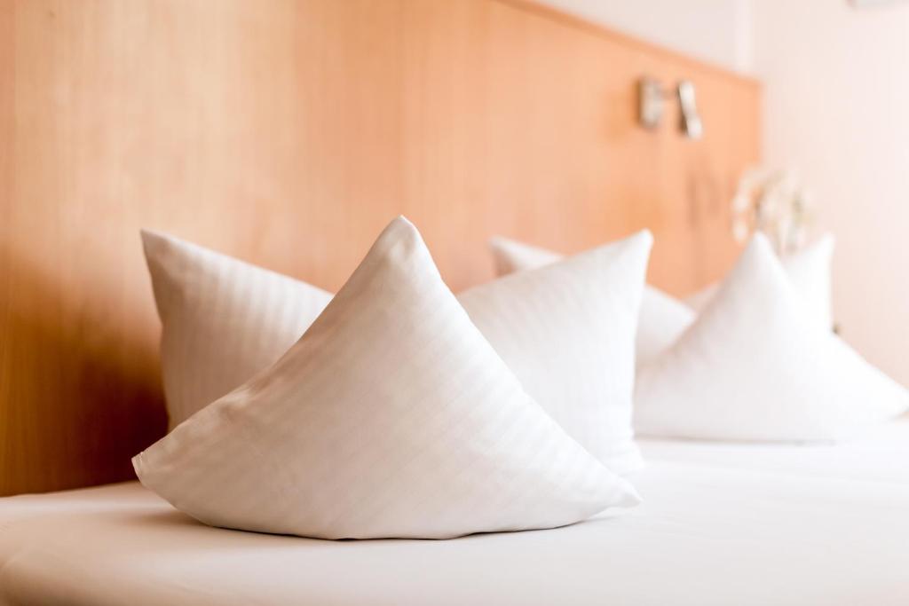 2 almohadas sentadas encima de una cama en Hotel Adler, en Waiblingen