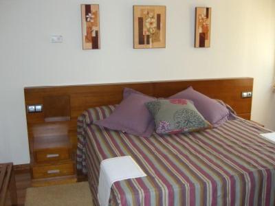 a bedroom with a bed with a wooden headboard at Hotel O Casino da Rasa in Nogueira de Ramuin