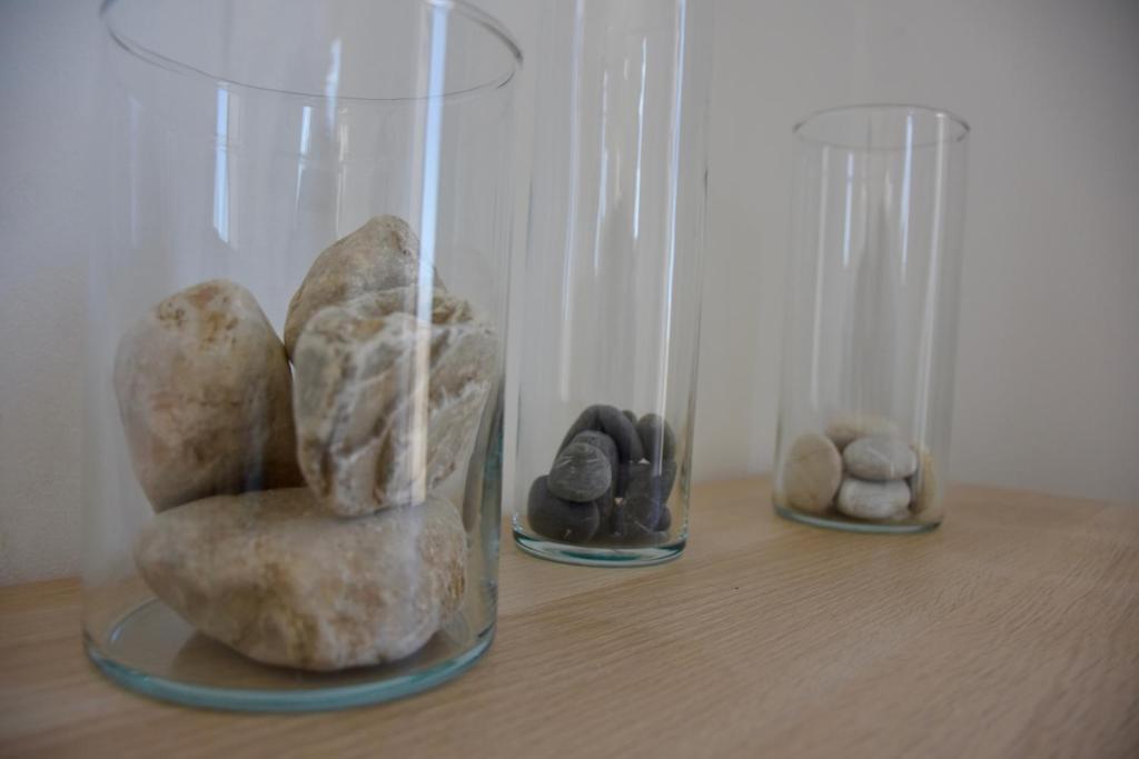 zwei Glasvasen mit Steinen auf dem Tisch in der Unterkunft SempreViva Sea Houses in Diakofti
