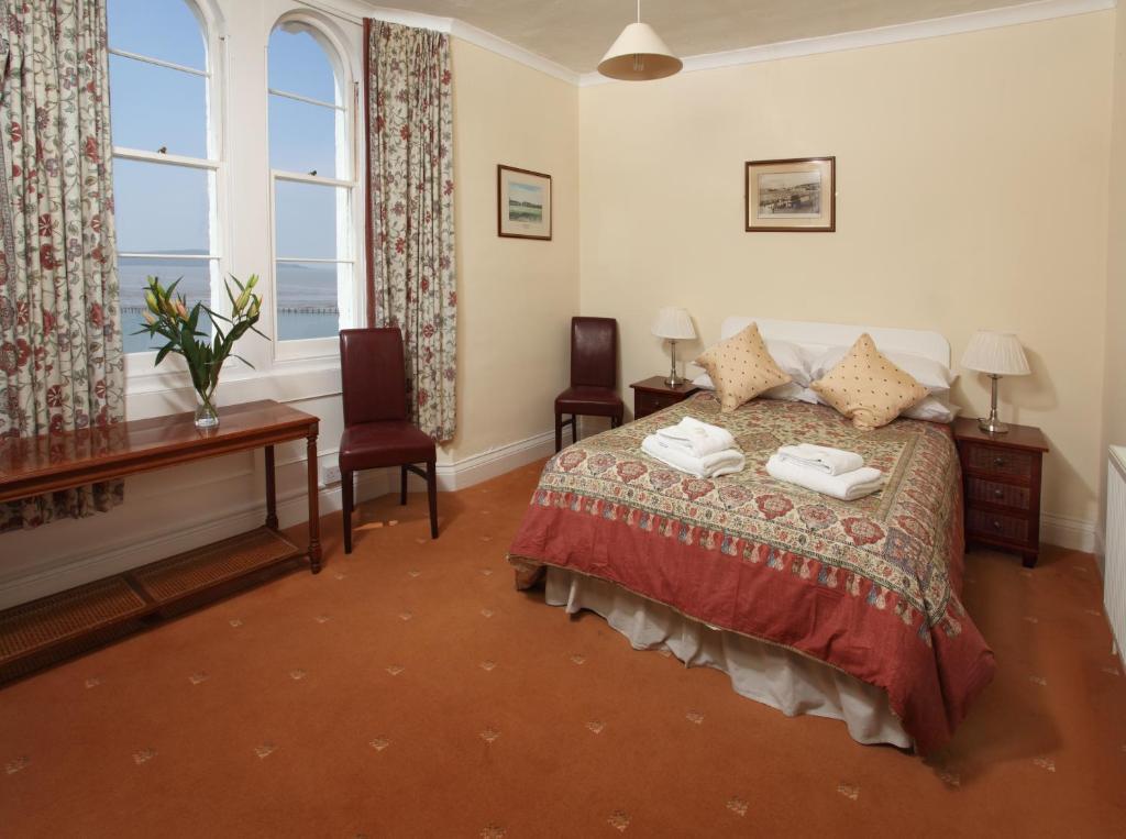um quarto com uma cama com 2 cadeiras e uma secretária em New Birchfield Hotel em Weston-super-Mare