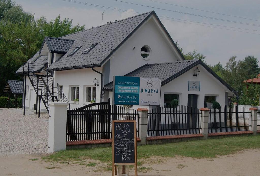 a white house with a sign in front of it at U Marka in Dąbrowy