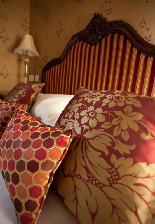 a bed with two pillows on top of it at Parc-Le-Breos House in Penclawdd