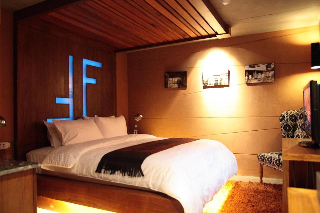 a bedroom with a large bed with a blue light at The Fusion Suites in Bangkok