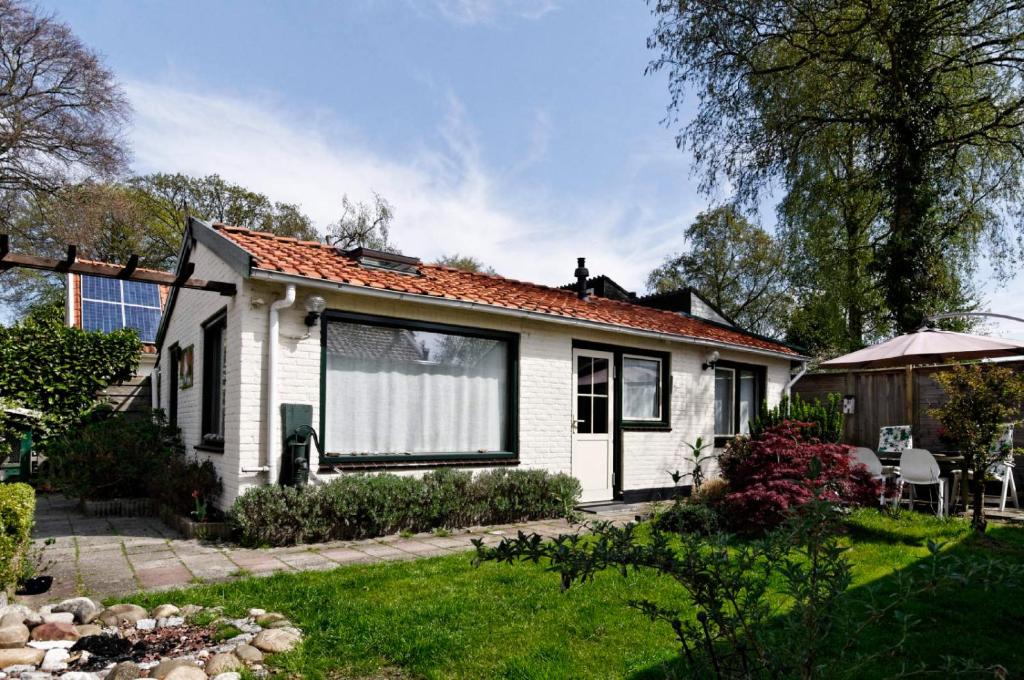una piccola casa bianca con giardino e prato di holiday cottage 'FLOW' a Bergen
