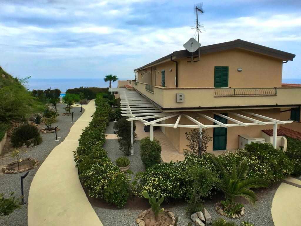 a building with a walkway leading to a garden at Chic Apartment in Parghelia Italy in Parghelia