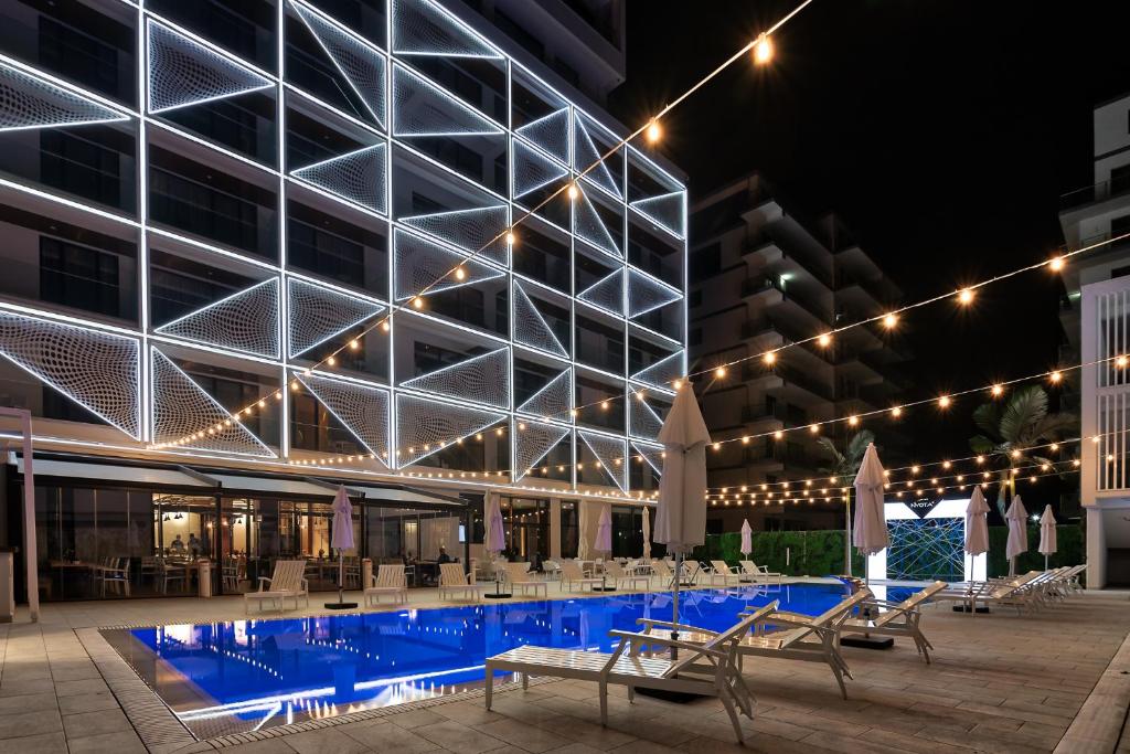 a large building with a swimming pool at night at Nyota Hotel & Conference Center in Mamaia